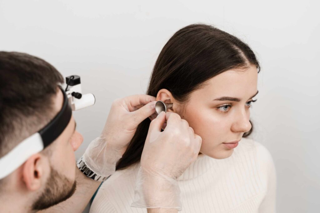 healthcare-professional-examining-young-woman-ear-for-ear-wax-removal-service