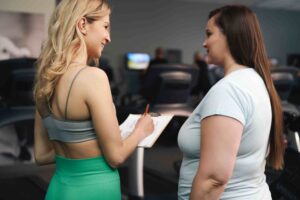 two-women-talking-together-at-the-gym-regarding-weight-loss-treatment