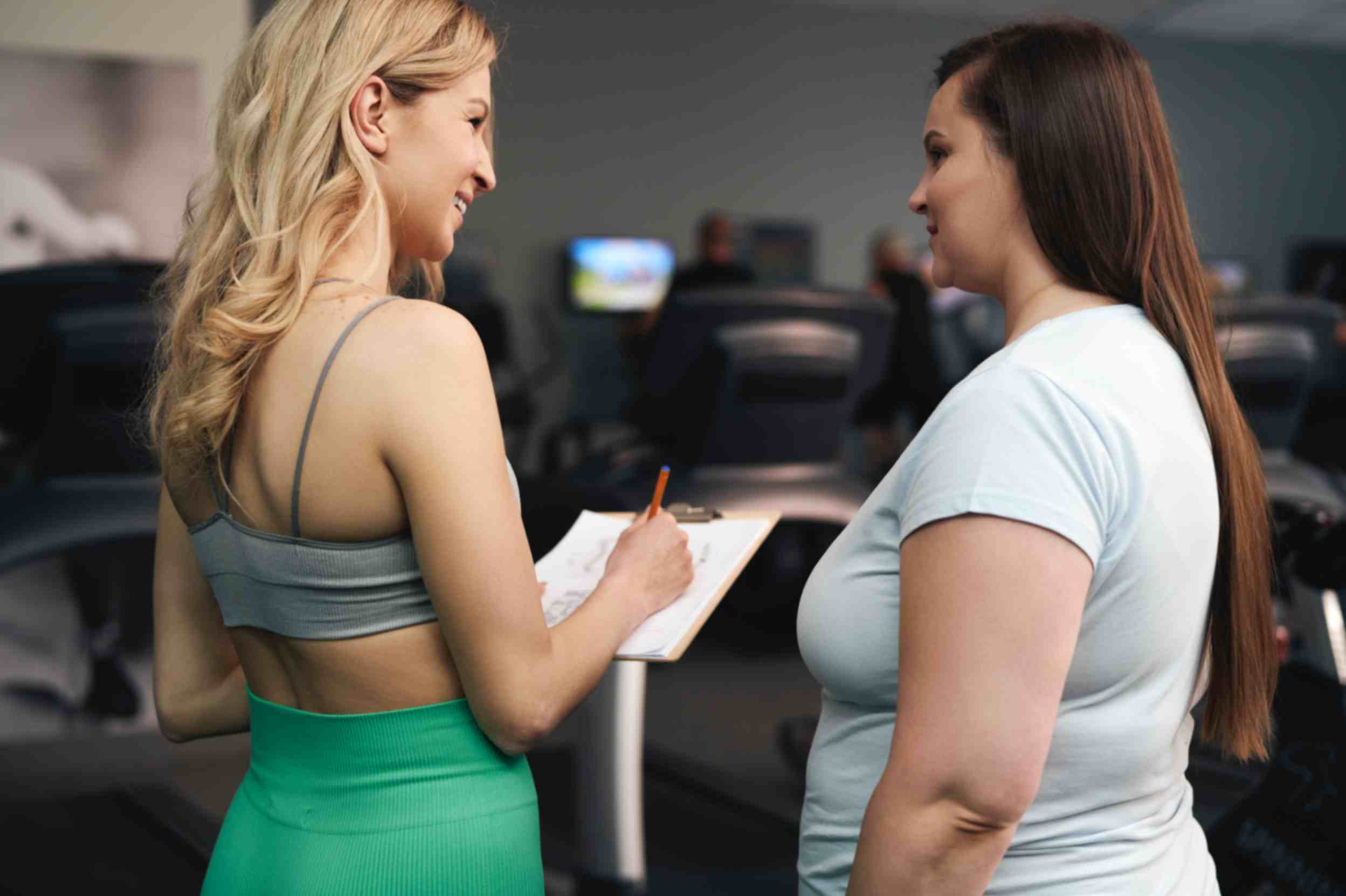 two-women-talking-together-at-the-gym-regarding-weight-loss-treatment
