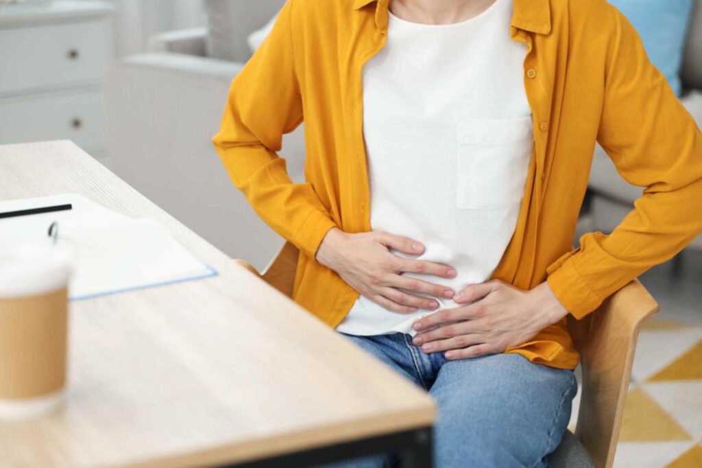 adult-holding-abdomen-in-discomfort-while-sitting-women-suffer-from-uti