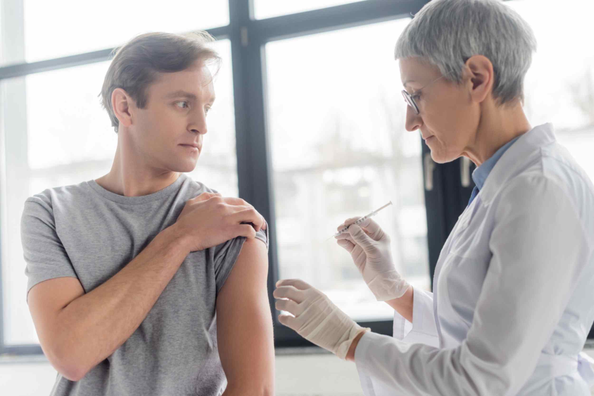 man-receiving-an-chickenpox-vaccine-from-a-pharmacy-professional
