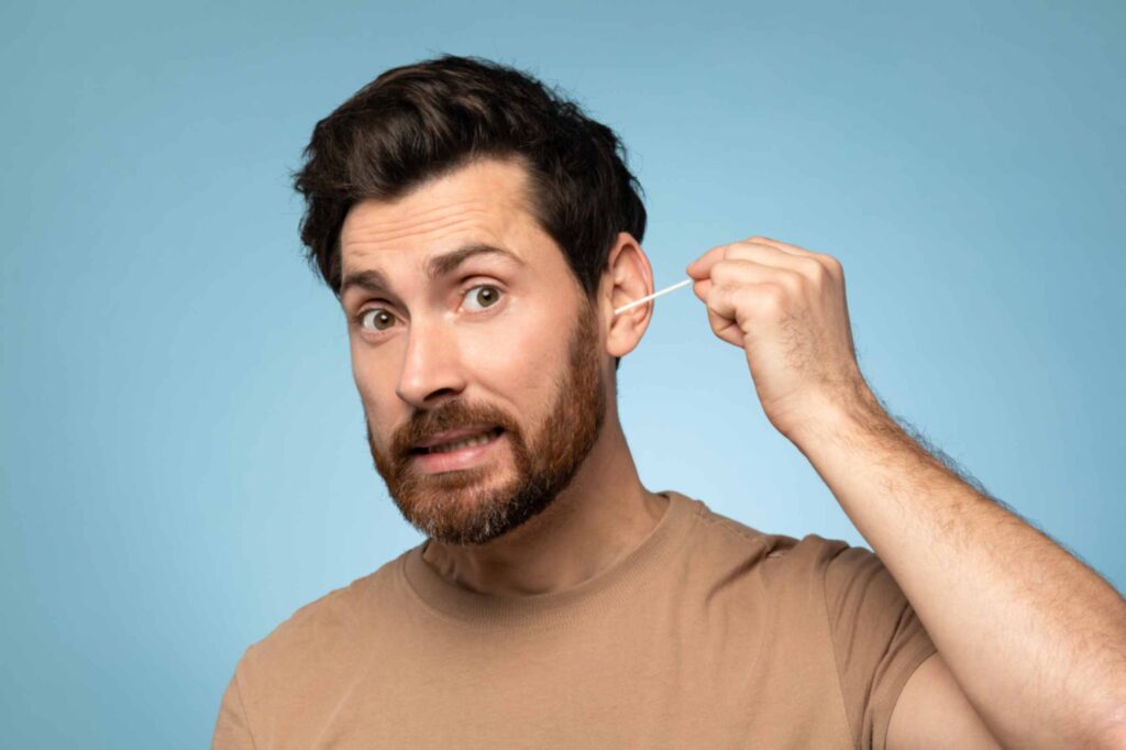 man-cleaning-ear-with-cotton-buds-indoors-